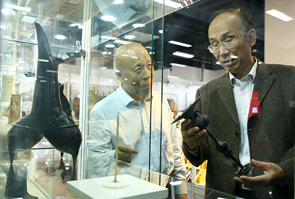 中国收藏家协会事业发展部主任李祥（左）为中国国家博物馆鉴定中心主任岳峰（右）介绍藏品